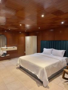 um quarto com uma cama grande e lençóis brancos em مساكن الدار 15 em Abha