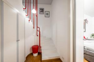 - un escalier dans une chambre blanche avec une poubelle rouge dans l'établissement [DUOMO in 5 minutes] Cozy and quiet, à Milan