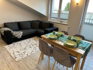 uma sala de estar com uma mesa e um sofá em WaMM Apartament em Zlotów