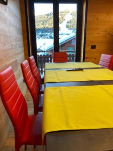 une table et des chaises jaunes dans une pièce avec fenêtre dans l'établissement Cronox Rin, à Livigno