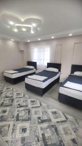 a bedroom with three beds and a rug at Engin HOME in Pamukkale