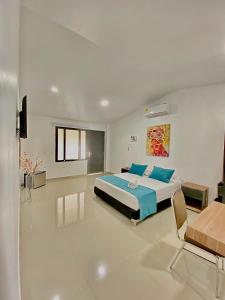 1 dormitorio con 1 cama en una habitación blanca en Hotel Boutique Duranta, en Villavicencio
