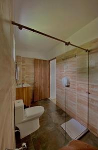 a bathroom with a toilet and a glass shower at Hotel Boutique Duranta in Villavicencio