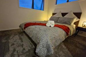 una camera da letto con un letto e due asciugamani di Lovely Brand New Home a Christchurch