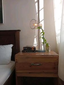 einen Nachttisch mit einem Ventilator neben einem Bett in der Unterkunft Serene Palace in Nairobi