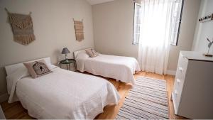 ポンタ・デルガダにあるWelcomeBuddy - Casa Memorial Miguel Faialのベッドルーム1室(ベッド2台、窓付)