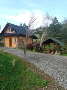 a house with a gravel road in front of it at Domek nad Stawem Siemuszowa in Tyrawa Wołoska