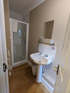 a white bathroom with a sink and a shower at Lakeside Lodge in Pidley