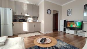 Apartament typu studio في فووتسوافيك: مطبخ وغرفة معيشة مع تلفزيون وطاولة