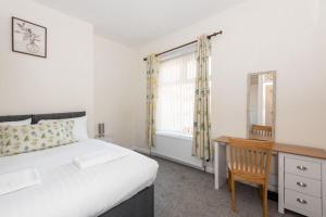 a bedroom with a bed and a desk and a window at The Westlands Apartment High Barnes Sunderland in Pallion