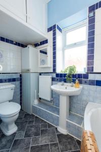 La salle de bains est pourvue de carrelage bleu, de toilettes et d'un lavabo. dans l'établissement The Westlands Apartment High Barnes Sunderland, à Pallion