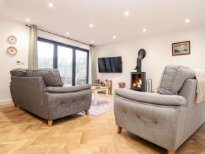 a living room with two chairs and a fireplace at Wildwood in Newquay