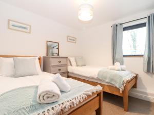 a bedroom with two beds and a window at Wildwood in Newquay