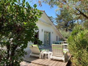 eine Terrasse mit zwei Stühlen und einem Tisch in der Unterkunft Villa Cap Ferret - Réf 230 in Lège-Cap-Ferret