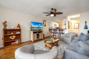una sala de estar con un sofá y una mesa en Kona Pacific C618 Top fl Seaview With ac, Elevator, en Kailua-Kona