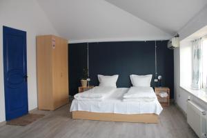 JR's هاوس في يريفان: غرفة نوم بسرير ابيض كبير بجدار ازرق
