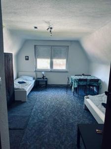 a room with two beds and a table in it at StadtHOUSE Bentheim Viel Platz für Gruppen in Bad Bentheim