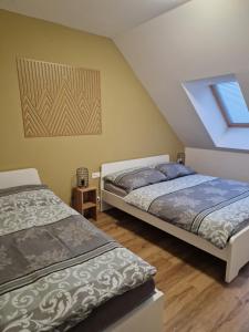 two beds in a room with a window at Apartmán Eliška Filipovice in Bělá pod Pradědem