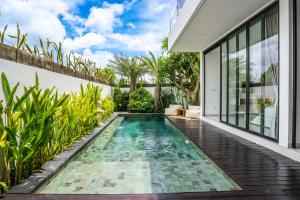 an infinity pool in the backyard of a house at Ozkar Villa Canggu in Canggu