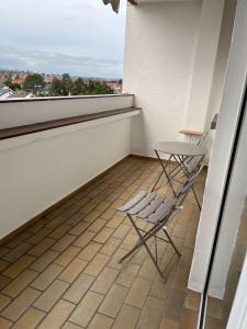 two chairs and a table on a balcony at Bruchköbel 2 auch für Monteure in Bruchköbel