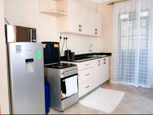 a kitchen with a refrigerator and a stove at Serene Palace in Nairobi