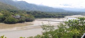 uma ponte suspensa sobre um rio com montanhas ao fundo em Querido Palmar em Santa Fe de Antioquia