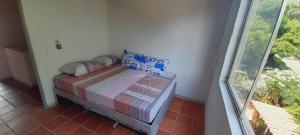 uma pequena cama num quarto com uma janela em Querido Palmar em Santa Fe de Antioquia