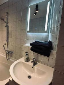 ein Bad mit einem Waschbecken, einer Dusche und einem Spiegel in der Unterkunft Personalunterkunft in Rheine mit Balkon in Rheine