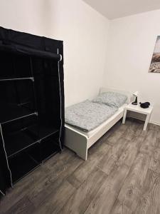 Schlafzimmer mit einem Bett und Holzboden in der Unterkunft Personalunterkunft in Rheine mit Balkon in Rheine
