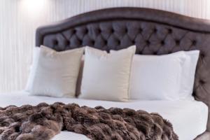 ein Bett mit weißen Kissen und einer braunen Decke in der Unterkunft PALAZZO RISTORI in Verona