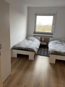 two beds in a room with a window at Bruchköbel 2 auch für Monteure in Bruchköbel