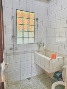a bathroom with a bath tub and a window at Villa Nuansa Alam in Lembang