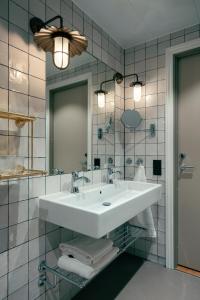a bathroom with a white sink and a mirror at Liseberg Grand Curiosa Hotel in Gothenburg