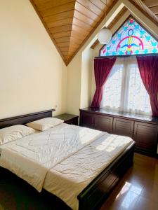 a bedroom with a bed and a stained glass window at Villa Nuansa Alam in Lembang