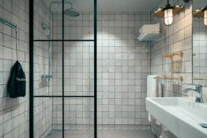 una puerta de ducha de cristal en un baño con lavabo en Liseberg Grand Curiosa Hotel en Gotemburgo