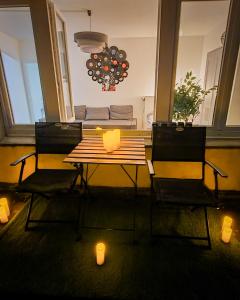 - une table et des chaises dans le salon avec bougies dans l'établissement Central and Cozy Haven in Geneva, à Genève