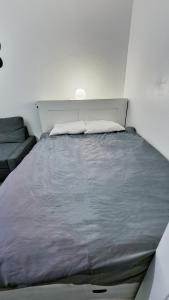 Ce lit se trouve dans une chambre blanche dotée d'un grand lit. dans l'établissement Central and Cozy Haven in Geneva, à Genève