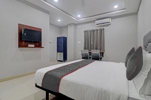 a bedroom with a bed and a flat screen tv at Collection O Hotel Lavish Springs in Hyderabad