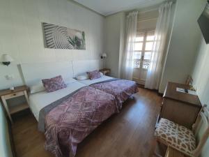 Un dormitorio con una cama grande y una ventana en Hostal Riesco, en Madrid