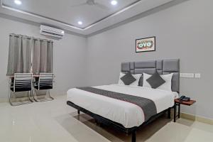 a bedroom with a bed and chairs in it at Collection O Hotel Lavish Springs in Hyderabad