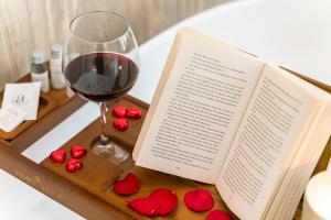 ヴェローナにあるPALAZZO RISTORIの本、ワイン一杯、赤いバラ