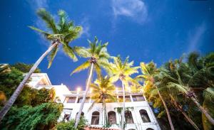 a building with palm trees in front of it at Boutique Beachfront Hotel on Isla Contadora in Contadora