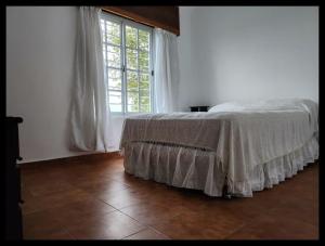 a bedroom with a bed and a large window at Casa Q a 5km del centro de Villa Carlos Paz in Villa Santa Cruz del Lago