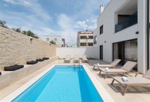 una piscina en el patio trasero de una casa en NEW ! Villa Bellatrix 2 - heated pool and jacuzzi, en Vrsi