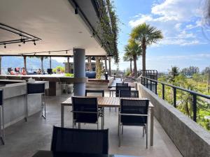 a restaurant with tables and chairs on a balcony at Kamala poolview 2 bedroom suite in Kamala Beach