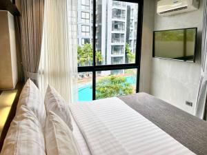 a bedroom with a bed and a large window at Kamala poolview 2 bedroom suite in Kamala Beach