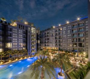 un grand bâtiment avec des palmiers devant dans l'établissement Kamala Beach P33 Pool view 2 Bedroom Suite, à Kamala Beach
