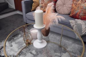 a candle on a glass table in front of a couch at Large 3 bed House Wolverhampton Families and Contractors in Wolverhampton