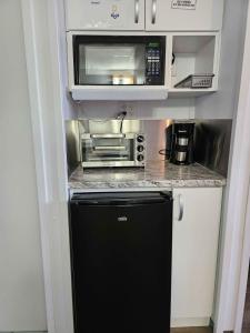 a small kitchen with a black refrigerator and microwave at Parc Octopus in Desbiens