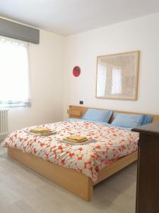een slaapkamer met een bed met een rood en wit dekbed bij Casa Venezia e Riviera in Mirano